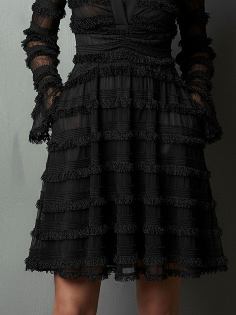 Vestido corto negro con flecos y transparencias por capas